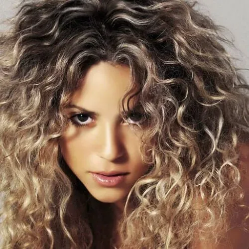 Shakira displaying golden defined ringlets - signature celebrity curly hairstyle with natural volume
