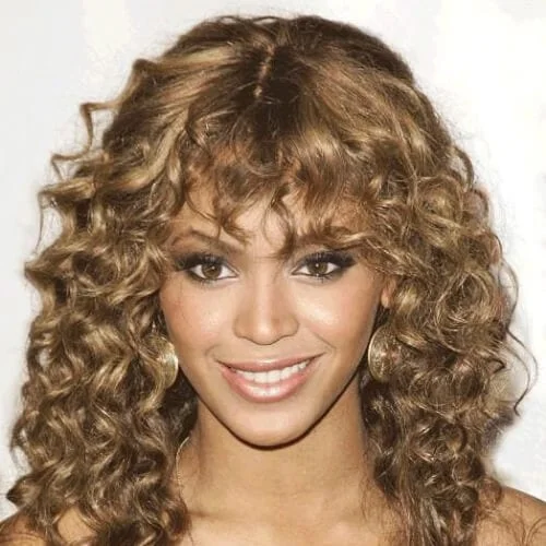 Beyoncé voluminous curls with bangs - fierce celebrity hairstyle with dramatic volume
