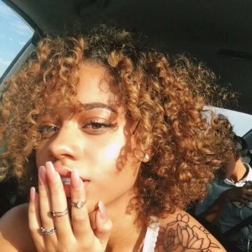 cinnamon curly hair with bangs