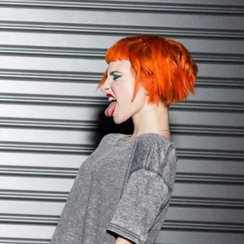 Orange short punk hairstyles with bright color and textured layers - bold hair transformation