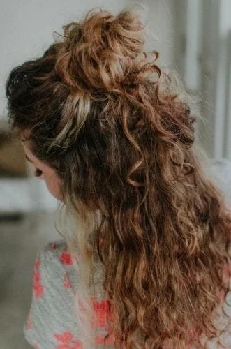 Easy half up half down hairstyle for naturally curly hair with messy bun