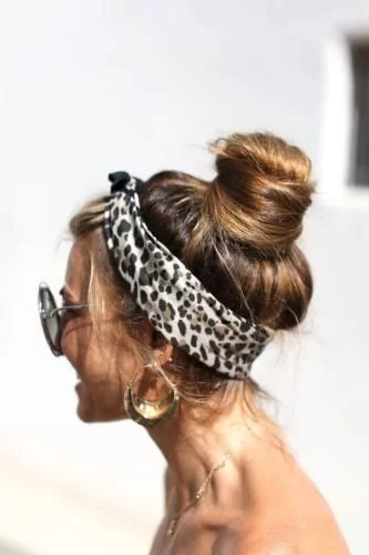 High complex bun hairstyle for long hair with bandana headscarf and wispy face-framing strands
