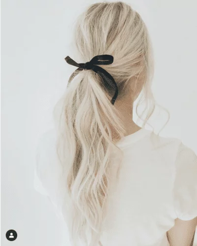 Elegant ponytail Thanksgiving hairstyle with black ribbon bow - simple yet sophisticated holiday look