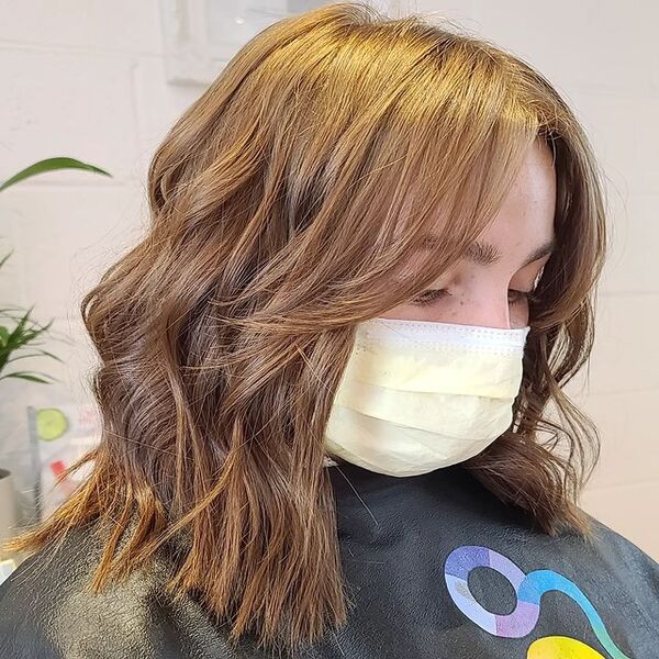 Ash Brown Brassy Color Curtain Bangs for Bob Hair - A woman wearing a yellow mask