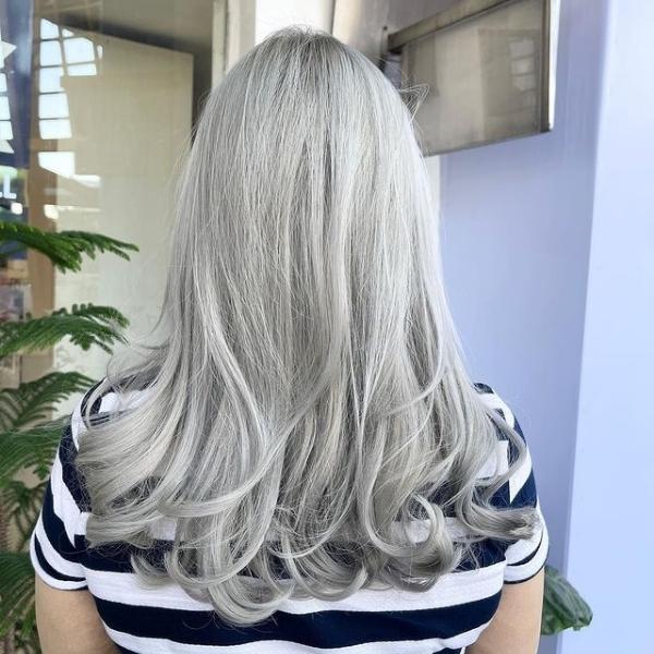 Ash Grey Blonde with Edge Curls - A woman wearing a stripe top