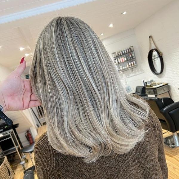 Creamy Blonde with Dark Roots - A woman inside a salon