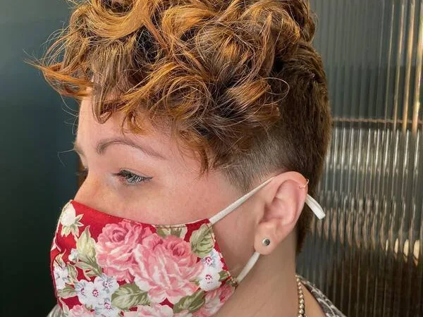 Curly Undercut Hair -A woman wearing a flower mask
