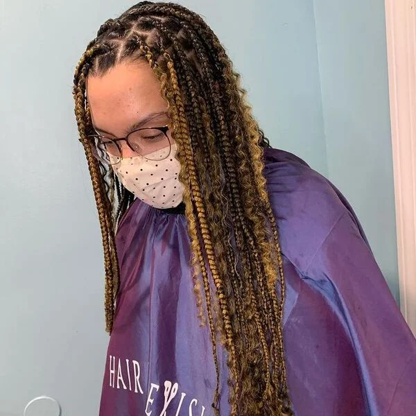 Goddess Knotless Braid Hairstyles with Weave - a woman wearing shiny salon cape.
