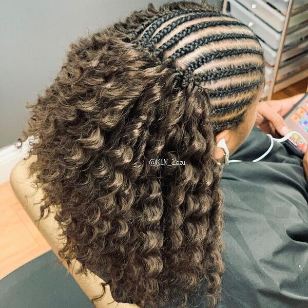 Half Cornrow Braid Hairstyles with Weave in Natural Curls - woman wearing salon cape.