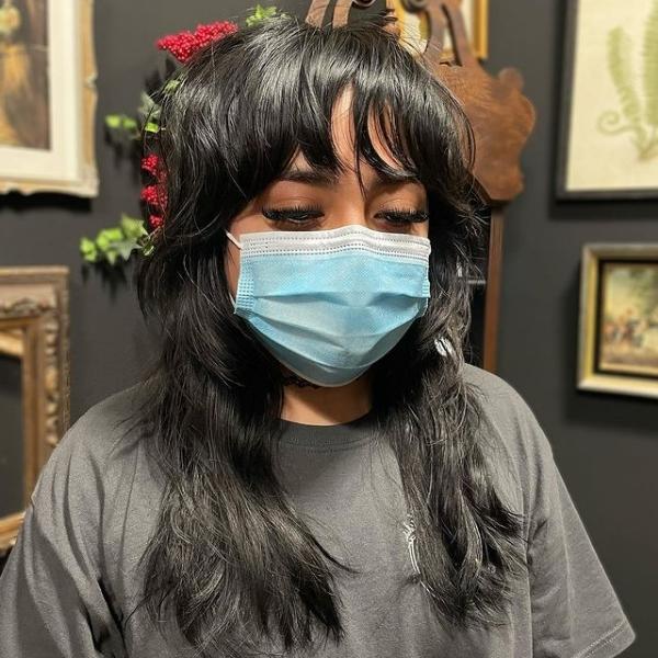 Natural Dark Black Wolf Cut - A woman wearing a surgical mask