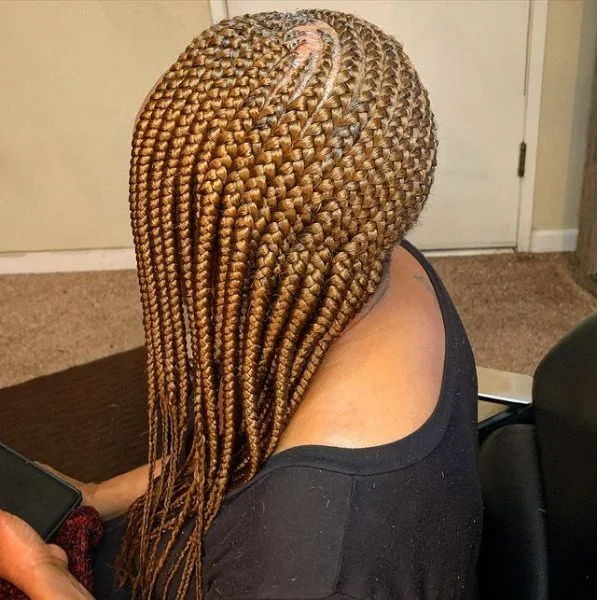 Rasta Lemonade Braids - A woman wearing a black top