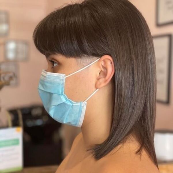 Short Straight Wolf Cut with Bangs - A woman wearing a surgical mask