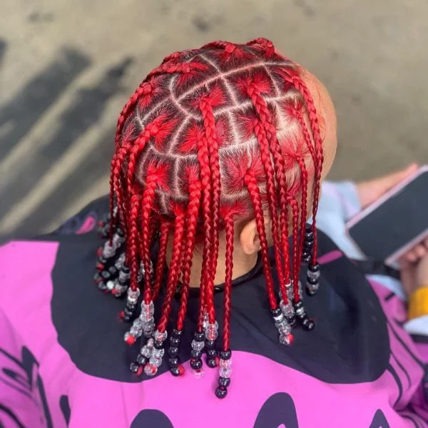 Spicy Red Braided Hairstyle - A woman wearing salon cape