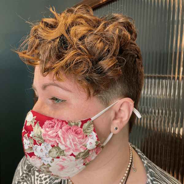 Undercut Pixie Curls on Top - A woman wearing a red mask