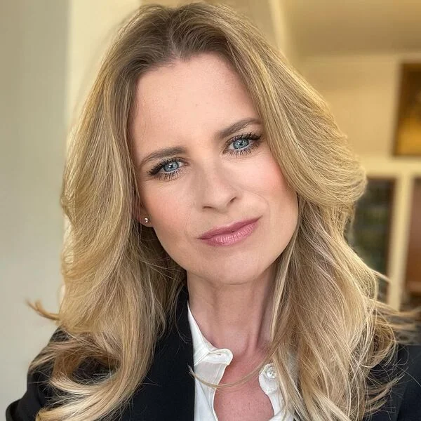 Blonde Ombre Hairstyle - a woman wearing black coat over white polo.