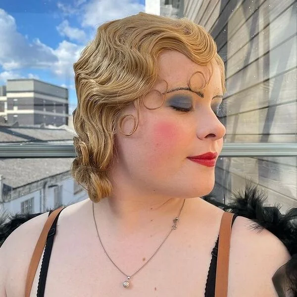 Blonde Thrash Mullet - a woman wearing full glam make-up in tank top and feathery coat.