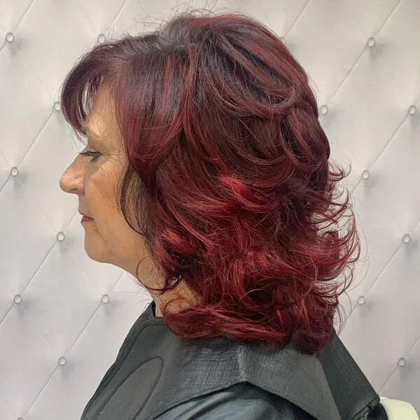 Burgundy Feathered Bob - a woman wearing black cape.