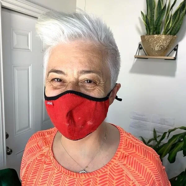 Cool Platinum White Spiky Pixie - a woman wearing orange top.