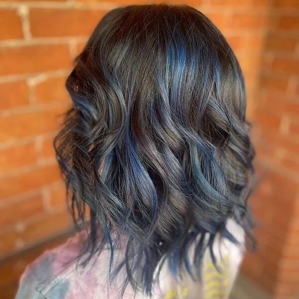 Curly Layers of Blue Bob Highlights - a woman wearing dyed shirt.