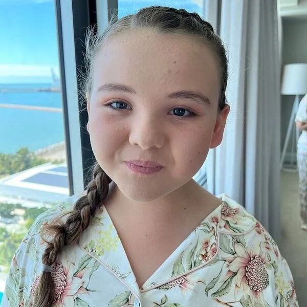 Curved Side Braid Pigtail Flower Girl Hairstyles- a girl is wearing floral robe.