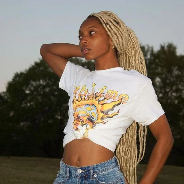 Extra Long Platinum Dreads - a woman is wearing white shirt with denim pants.