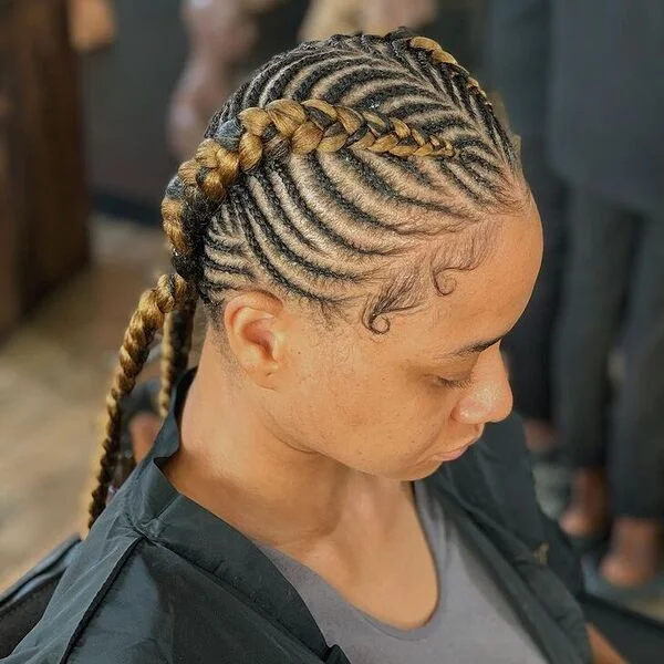 Fishbone Feed-in Braids - a woman wearing salon cape over gray shirt.