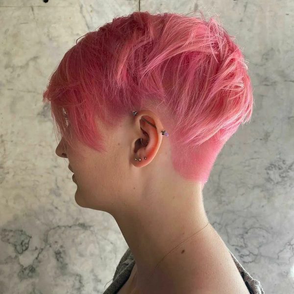Messy Pink Shaved Nape Pixie - a woman wearing gray cardigan.