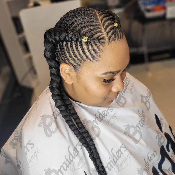 Pigtail Fishbone Braids with Beads - a woman wearing printed white salon cape.