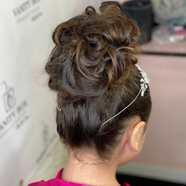 Tousled High Bun Hairstyle - a girl wearing pink top.