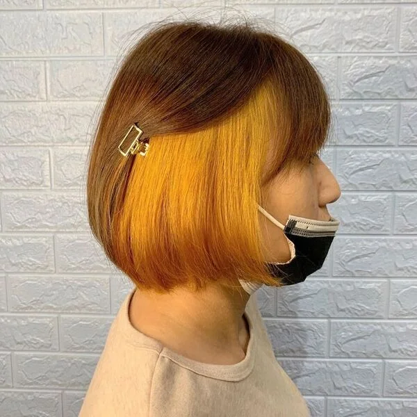 a woman wearing hair clip in mask and nude shirt.