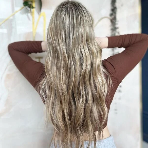 wavy balayage V cut hairstyle - blonde highlights on V-shaped layered haircut