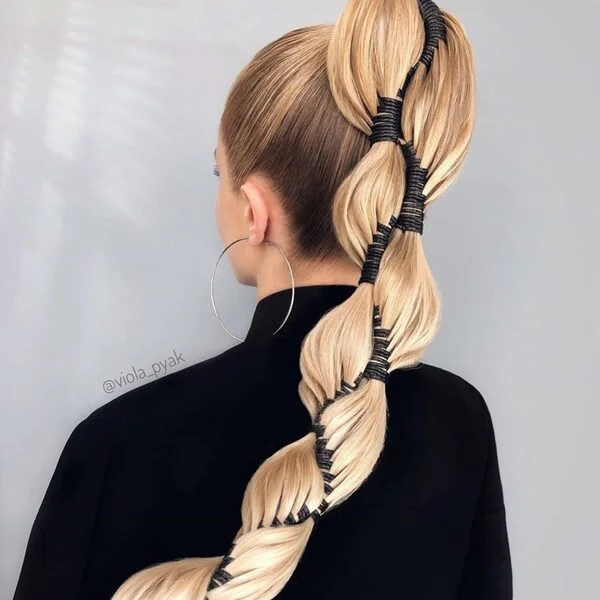 Classy High Viking Ponytail - a woman wearing black turtle neck top