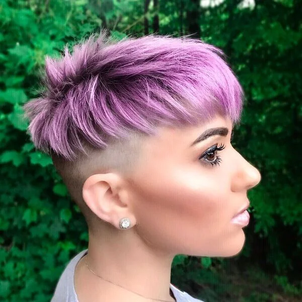 Bold purple pixie cut with shaved undercut sides and vibrant color gradient - edgy short sassy haircut for fair skin tones