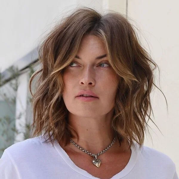 Trendy messy blonde-highlighted brown bob with middle part and tousled waves - contemporary short sassy haircut for cool skin tones