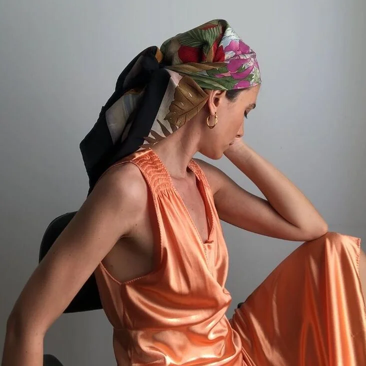 A woman wearing orange long silk dress