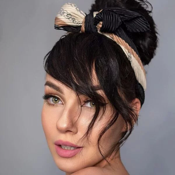a woman wearing full make up in off shoulder style top had her hair styled to Big Bun Ribbon Knot Scarf Headband