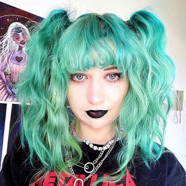 a woman wearing printed black shirt in punk make up had a turquoise hair color