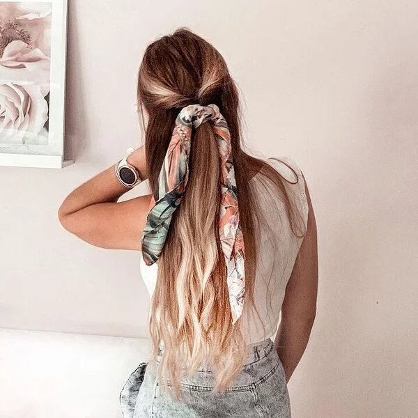 Woman in white tank top demonstrating half up scarf knotted hairstyle with bandana