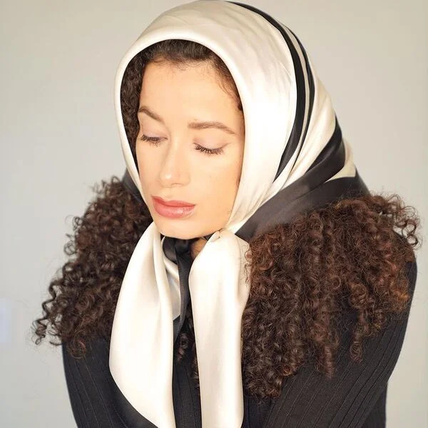 A curly haired woman wearing black