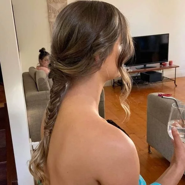 a woman wearing blue floral top had her hair styled to Single Fishtail with Curled Side Bangs for her graduation