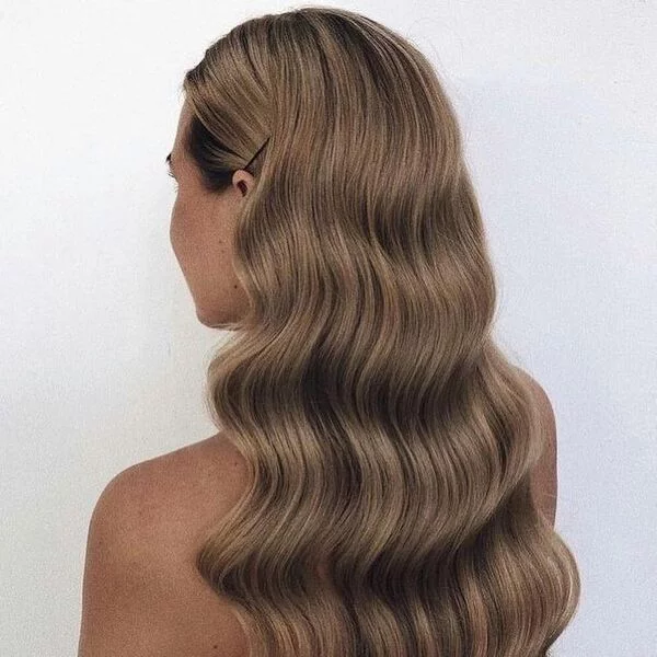 a woman wearing backless top had her hair styled to Stunning Curls with Bobby Pins for her graduation