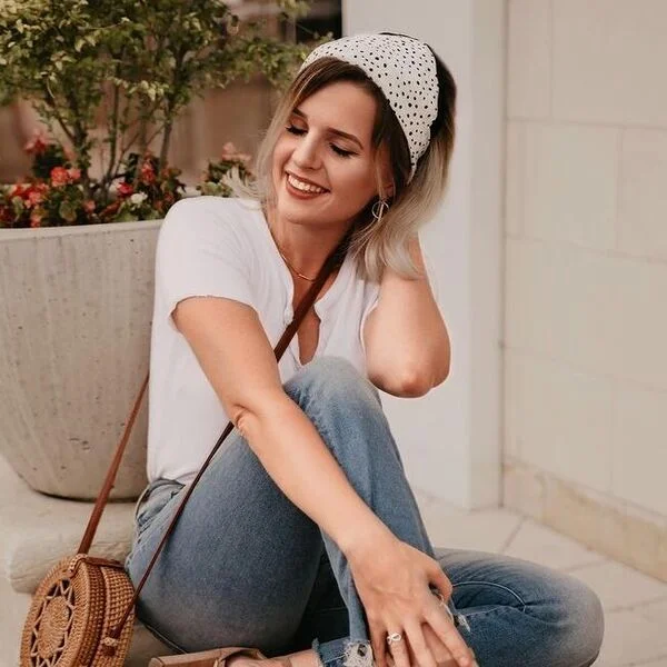 a woman wearing white top with jeans and bag had her hair styled to a Triangle Band Scarf on Bob