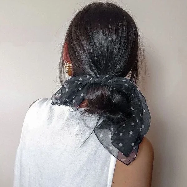 A woman wearing polka dots scarf in white top